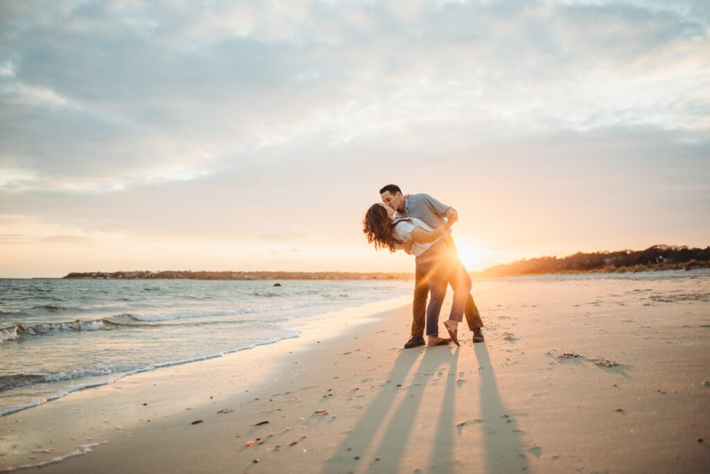 Sunset engagement session at Long Beach in Centerville, Cape Cod, featuring a stunning backdrop of the ocean and vibrant colors of the setting sun.